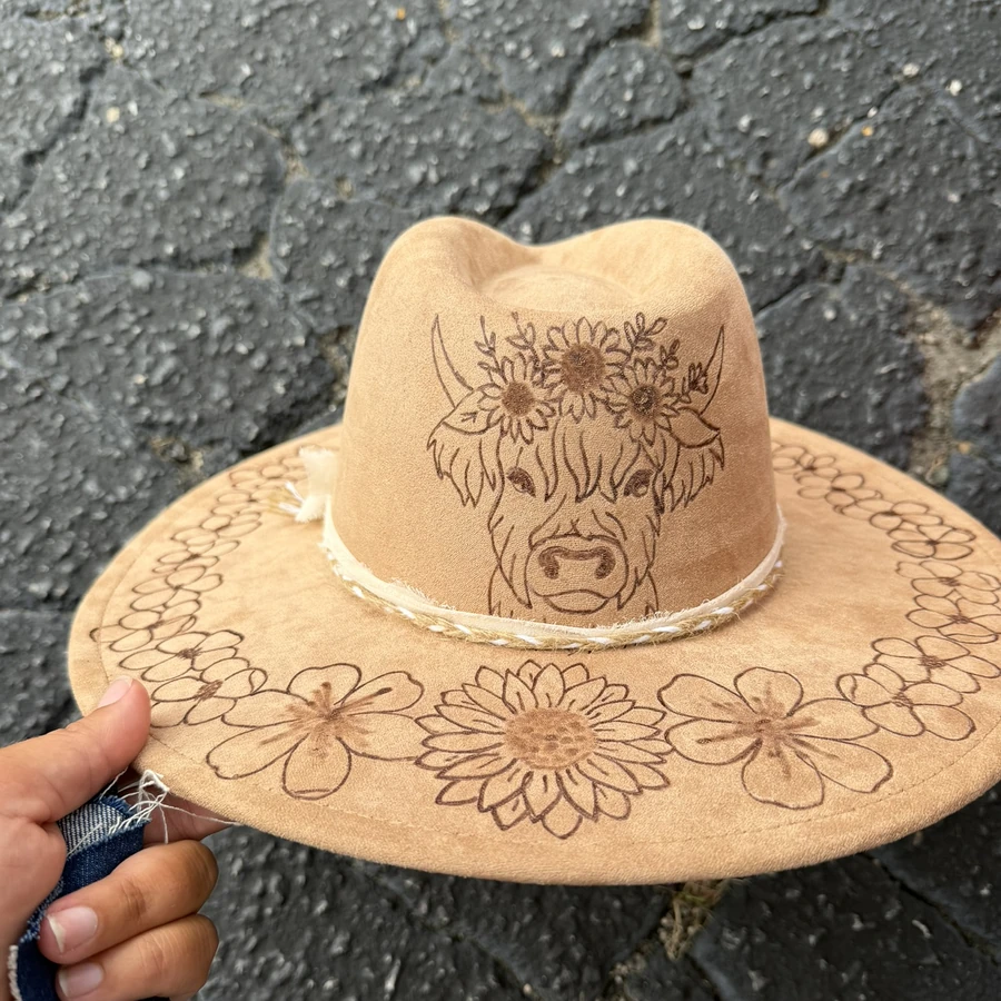 Tan suede hat with a hand-burned highland cow and sunflowers