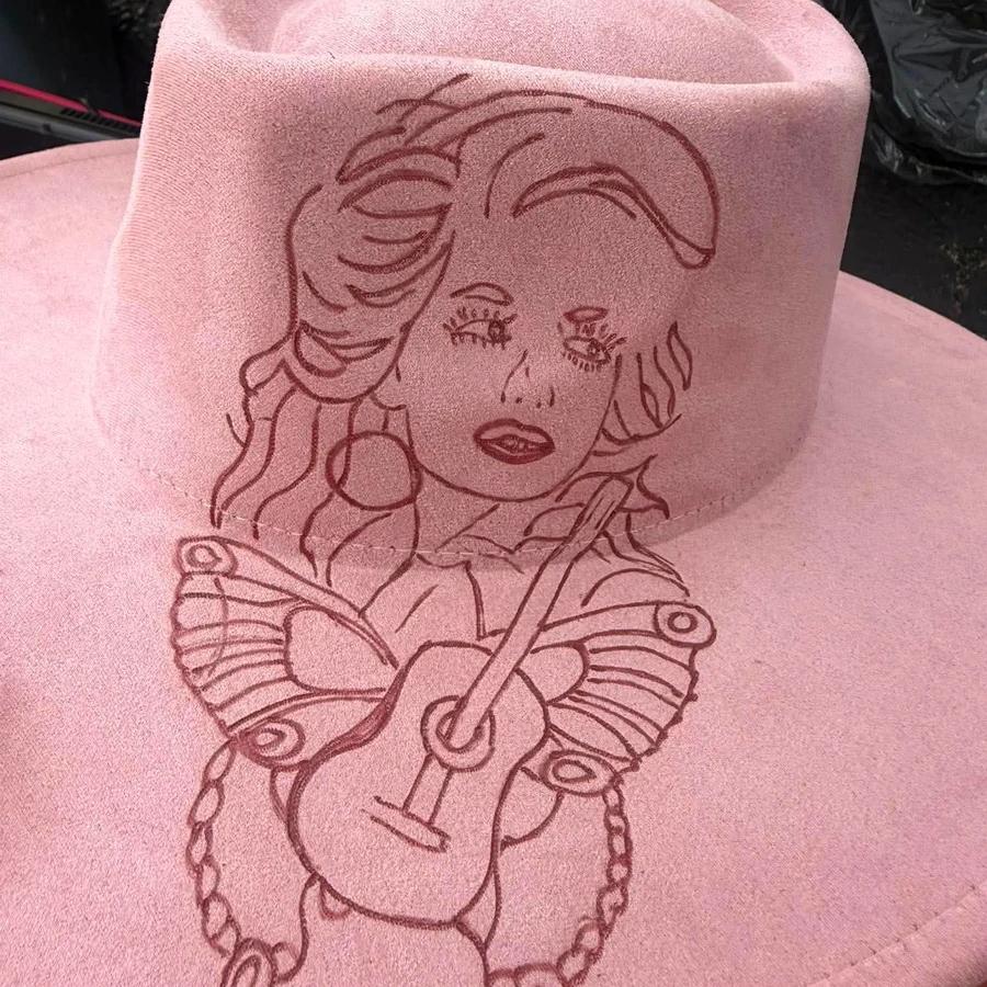 Pink suede hat hand-burned with a portrait of Dolly Parton holding a guitar